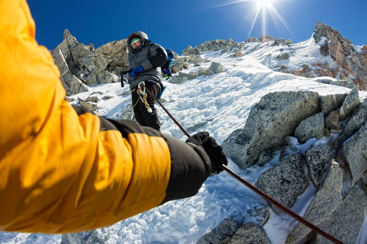 Bergsteiger am Seil bei der Besteigung des Kilimandscharo auf einem steilen, schneebedeckten Abschnitt