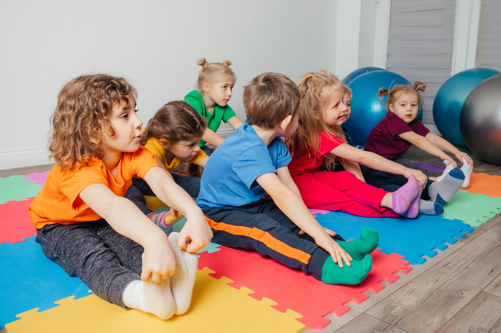 Kinder machen Dehnübungen auf Matten | Osteopathie Freiburg