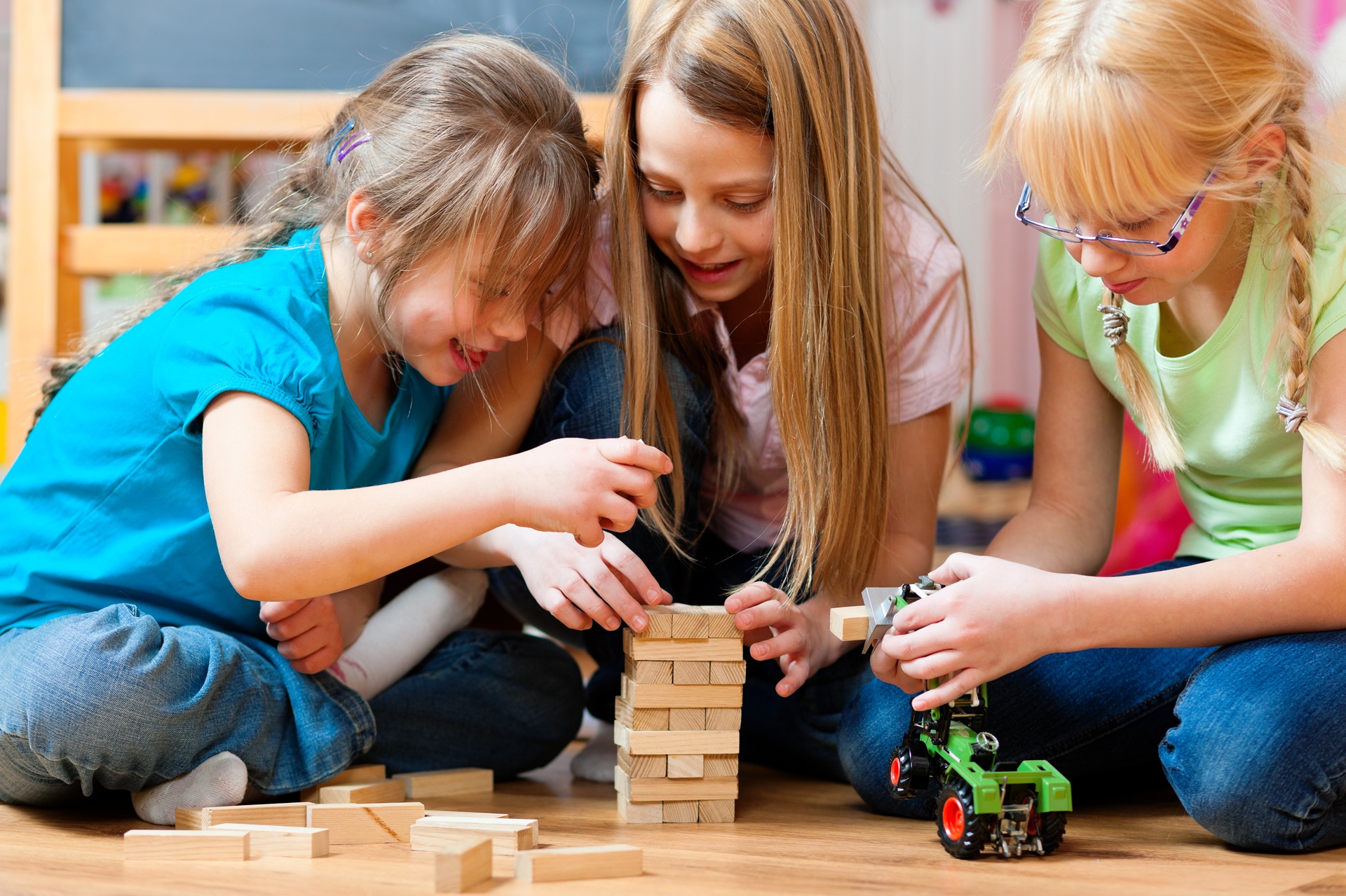 Drei Maedchen spielen mit Holzsteinen | Spielplatzgeräte
